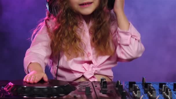 Niña con auriculares juega para la consola de DJ. Movimiento lento — Vídeos de Stock