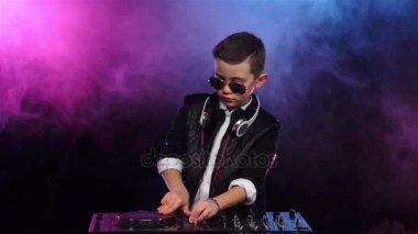 Vinil oynarken gözlüklü çocuk. Dumanlı arka plan, ağır çekim