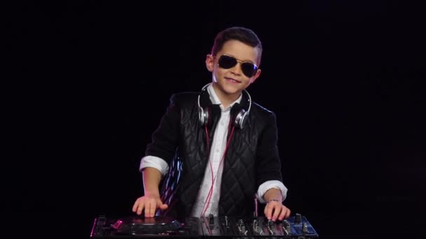 Boy dj v brýlích hraje hudba. Černé pozadí, pomalý pohyb — Stock video