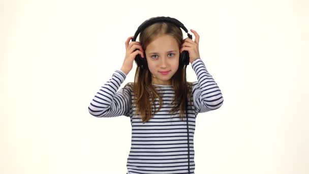 Dítě klade na sluchátka, začíná tanec na hudbu. Zpomalený pohyb — Stock video
