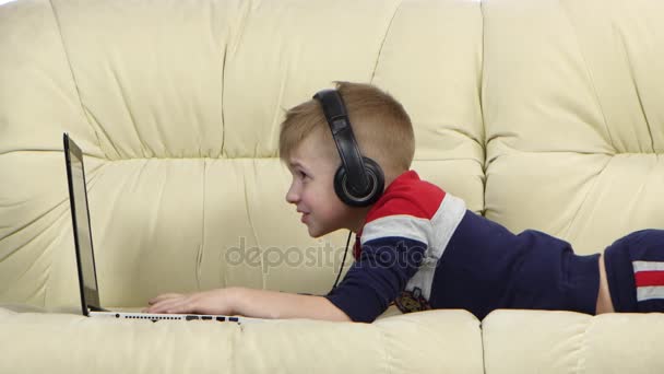 Chlapec, hraní online her na notebooku v gauči, zblízka — Stock video