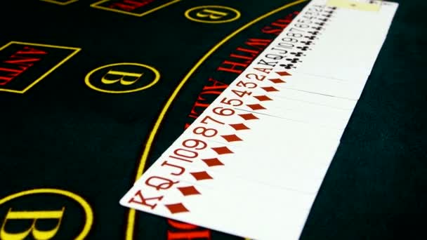 Playing cards are spread out on green surface poker table — Stock Video