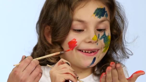 Dzieci zaczynają malować na ich twarzach, z frędzlami. Białe tło. Zwolnionym tempie — Wideo stockowe