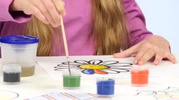 Κοπέλα ζωγραφίζει μια παιδική φιγούρα με χρώματα και ένα πινέλο. Κοντινό πλάνο — Αρχείο Βίντεο
