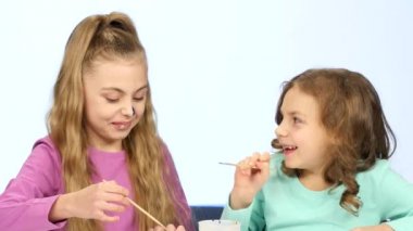 İki küçük kız onların yüz farklı renklerle boyayın. Yakın çekim. Beyaz arka plan