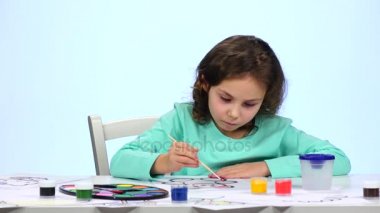 Çocuk ile kalemler bir resim boya ve çalışmalarını takdir ediyorum. Yakın çekim. Beyaz arka plan. Zaman atlamalı