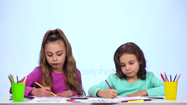 Sestry děti zdobí obrázek s tužky. Bílé pozadí. Zpomalený pohyb — Stock video