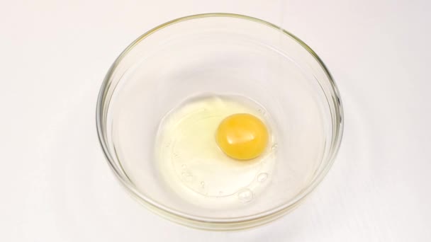 Разбивание яиц для приготовления в стеклянном глубоком блюде, замедленная съемка — стоковое видео
