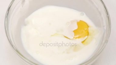 Bir yumurta levha süt ile düşüyor. Portre, ağır çekim