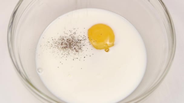 Le poivre est ajouté à l'œuf avec du lait au ralenti — Video