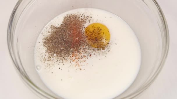 Leche con huevo espolvorear con la mezcla de pimienta primer plano. Movimiento lento — Vídeo de stock