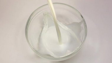 Süt cam şeffaf kase içine dökülür. Portre, ağır çekim