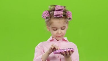 Curlers çocukta bir fırça ile onun göz kapaklarını boyar. Yeşil ekran