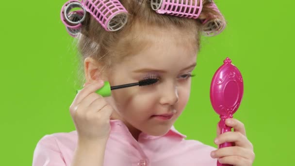 Babies look in the mirror and paint mascara eyelashes. Green screen. Close up — Stock Video