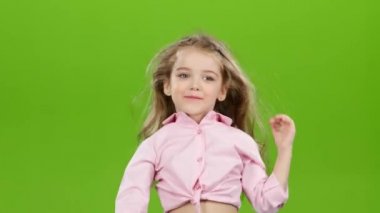 Çocuk curlers kaldırır ve onun uzun saç tarama başlar. Yeşil ekran