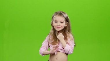 Küçük kız onun uzun saç tarama başlar. Yeşil ekran. Ağır çekim