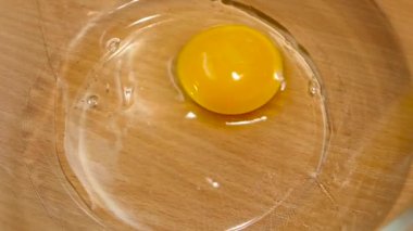 Derin cam tabak, yavaş hareket içinde yemek pişirmek için yumurta kırma