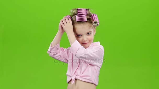 Dítě s natáčky na hlavě, odstraní natáčky. Zelená obrazovka. Zpomalený pohyb — Stock video