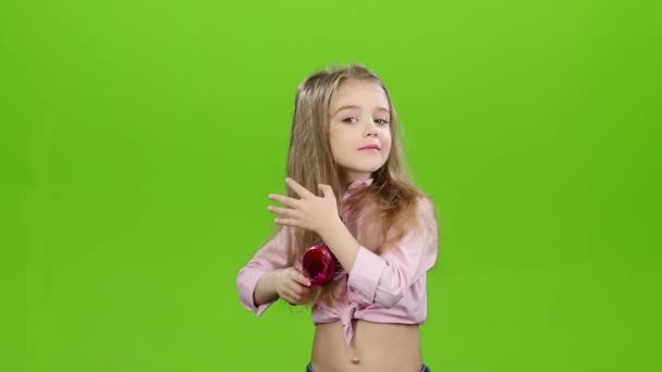 Μικρό κορίτσι αρχίζει να χτενίζει τα μαλλιά του μακριά. Πράσινη οθόνη. Αργή κίνηση — Αρχείο Βίντεο