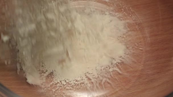 La farine de blé est versée dans un bol en verre. Mouvement lent, gros plan 