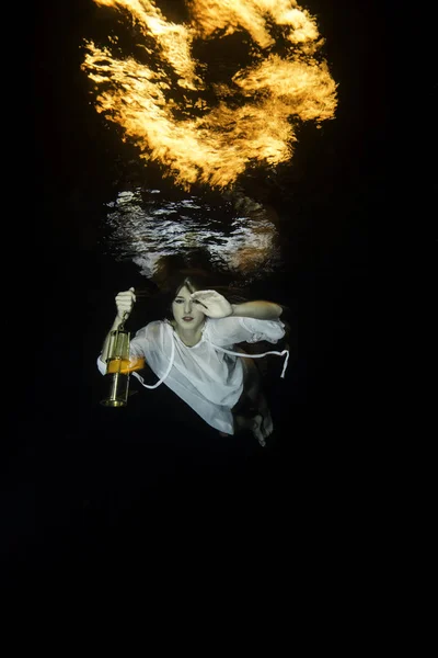Bianco vestito donna si tuffa con un laterno sott'acqua — Foto Stock