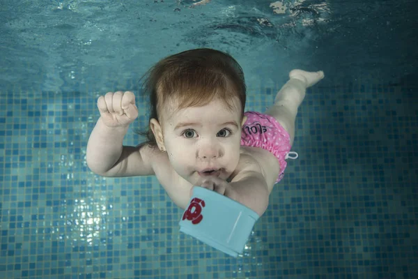 Little baby dives with blue cup — Stock Photo, Image