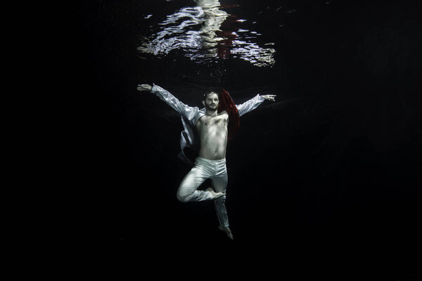 Молодой артист балета позирует под водой
