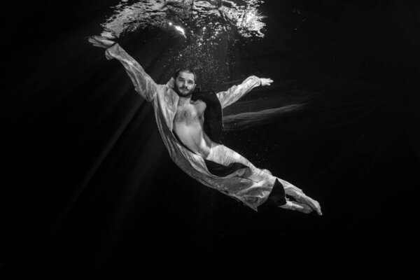 Молодой артист балета позирует под водой

