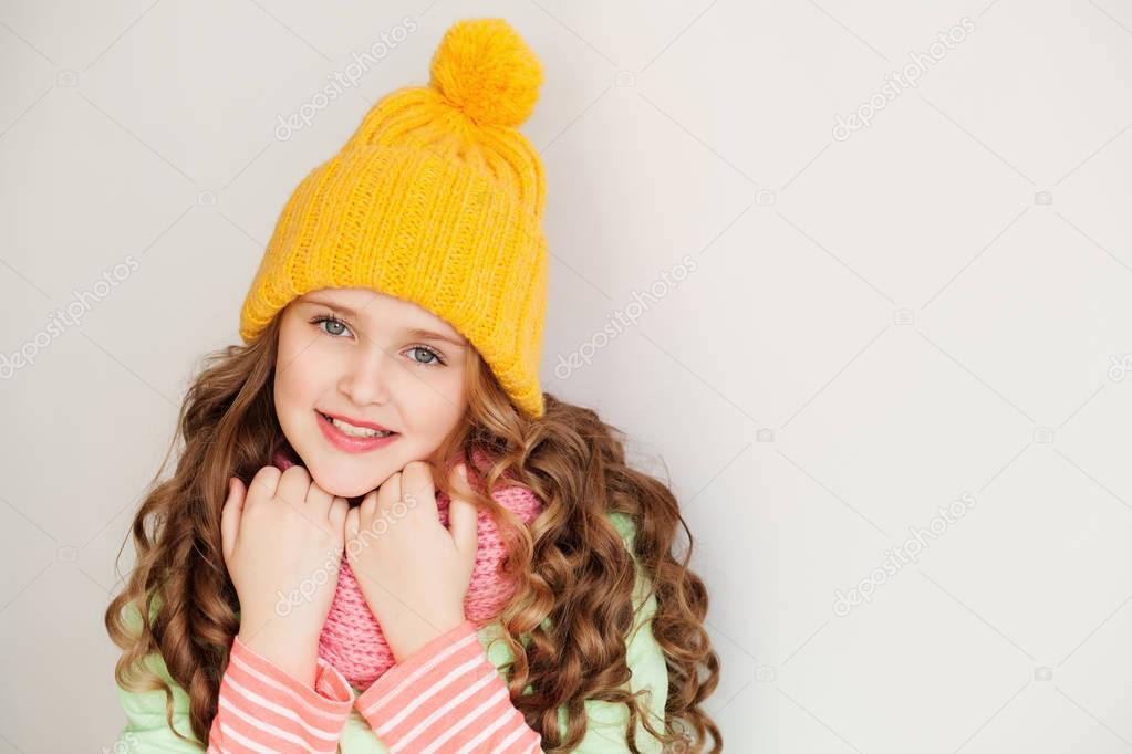 Cute little lady wearing yellow woolen cap and warm scarf 