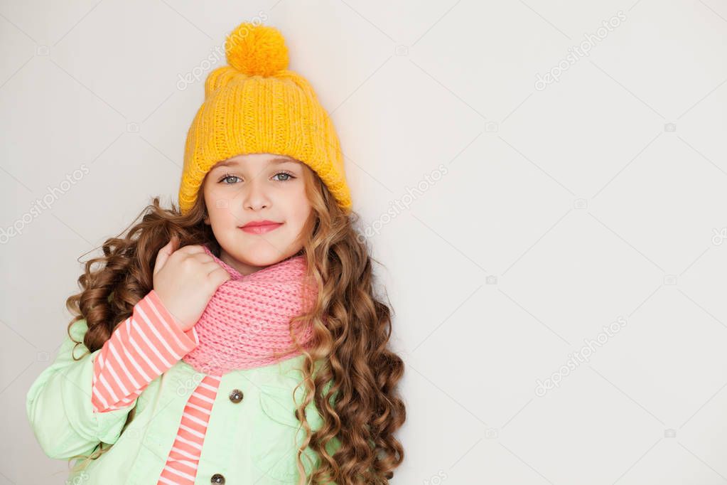 Cute little lady wearing yellow woolen cap and scarf 