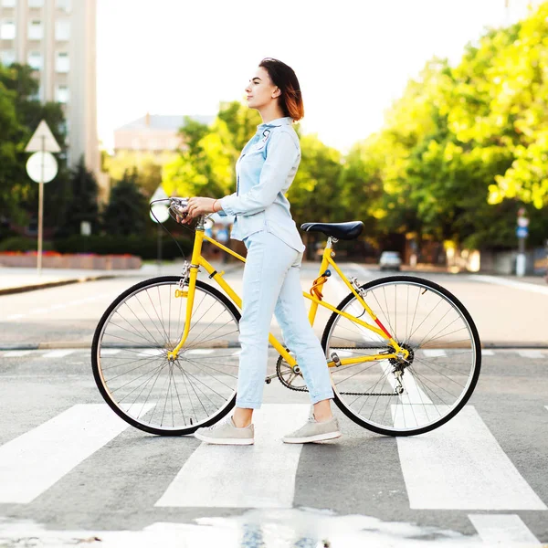 Belle femme avec un vélo sur la route — Photo