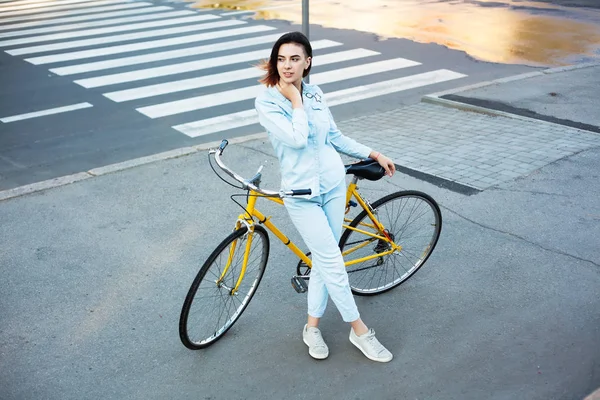 Mujer encantadora con una bicicleta en la carretera —  Fotos de Stock