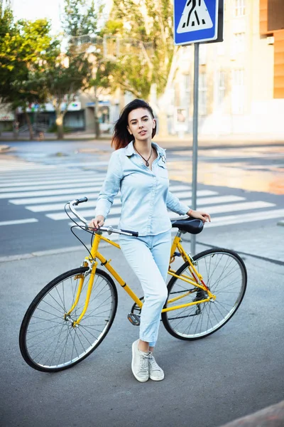 Mujer encantadora con una bicicleta en la carretera —  Fotos de Stock