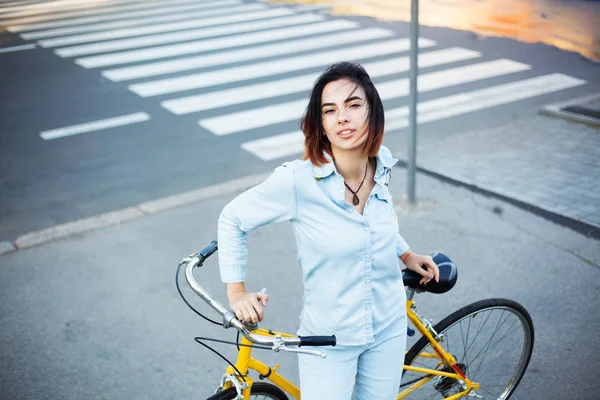 Mujer encantadora con una bicicleta en la carretera —  Fotos de Stock