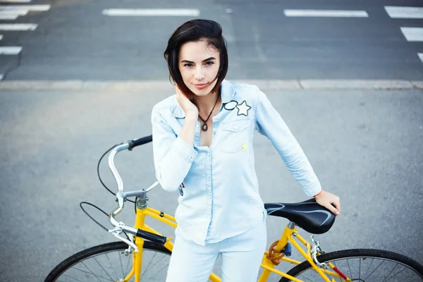 Милая женщина с велосипедом на дороге — стоковое фото