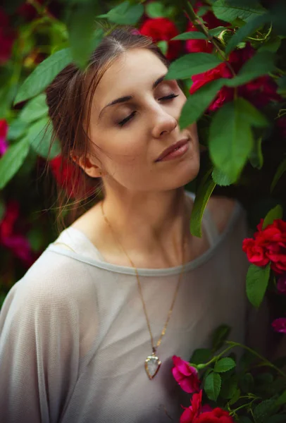 Schöne zarte Frau im Rosengarten — Stockfoto