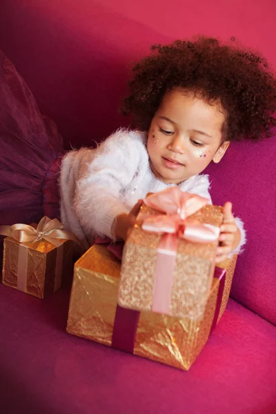 Χαριτωμένο κοριτσάκι με πολλά κουτιά δώρων κάθεται στον καναπέ — Φωτογραφία Αρχείου