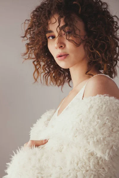 Belle femme aux cheveux bouclés sur fond gris — Photo