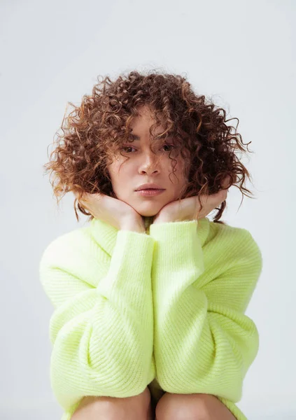 Schöne Frau mit lockigem Haar in warmem, gemütlichem Pullover — Stockfoto