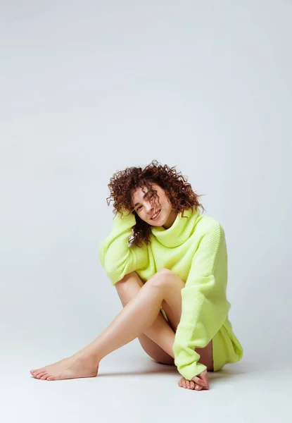 Portret van een mooie vrouw met krullend haar in warme, gezellige trui — Stockfoto