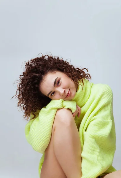 Portret van een mooie vrouw met krullend haar in warme, gezellige trui — Stockfoto