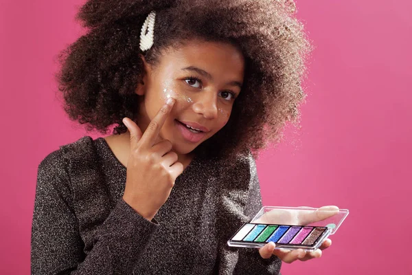 Lovely teenage girl applying festive makeup — Stock Photo, Image