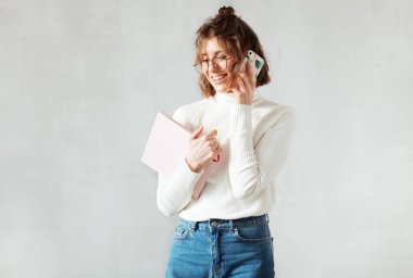 Planlı ve akıllı telefonlu güzel, gülen bir kadın.