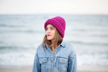 Kot ceketli ve örgü şapkalı güzel bir kadın.