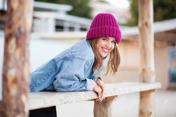 Jonge mooie vrouw in spijkerjasje en gebreide muts — Stockfoto