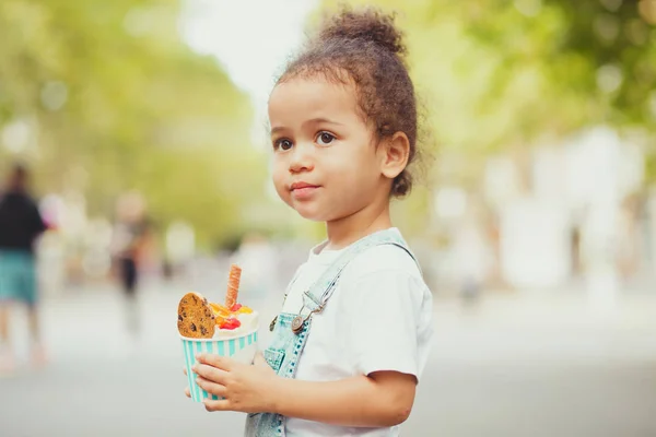 Мила дівчинка їсть морозиво на вулиці — стокове фото