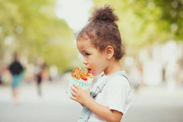 Menina bonito comer sorvete na rua — Fotografia de Stock