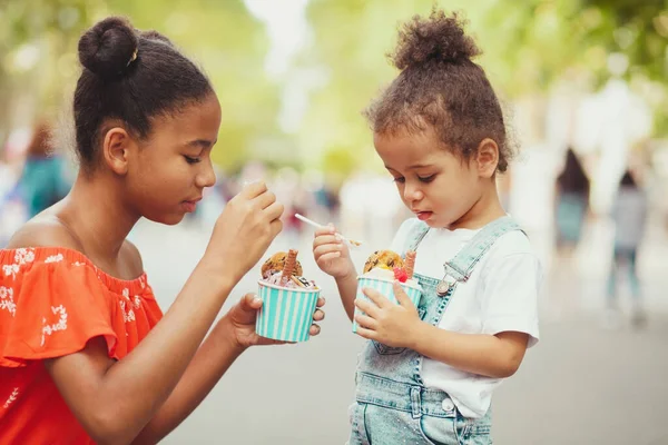 Leuke zusjes die ijs eten op straat — Stockfoto