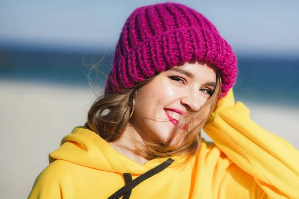 Mujer hermosa joven en sudadera amarilla y sombrero de punto púrpura brillante — Foto de Stock