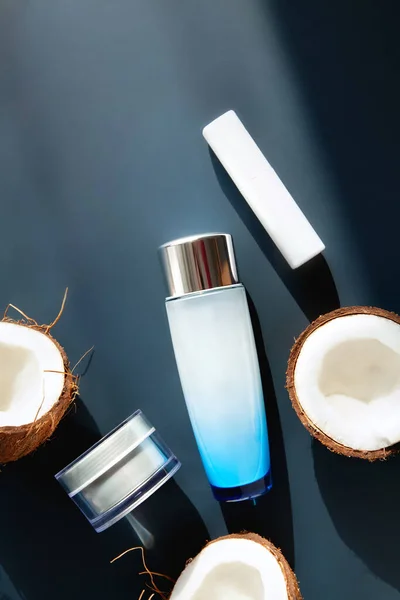 Uppsättning Naturliga Kosmetiska Produkter Med Kokosnötter Ligger Mörkblå Bakgrund — Stockfoto
